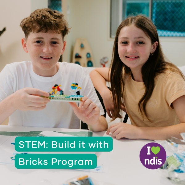 Two children engaging in the Therapy at Home STEM: Build it with Bricks Program, proudly showing off their brick creation.