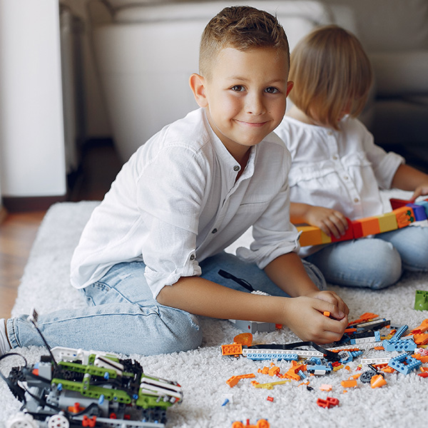 Primary school child playing lego with his sister