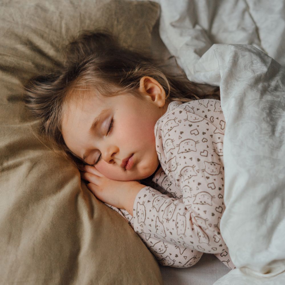 young girl asleep in bed