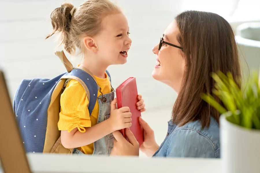 Happy Mother and child with school bag and books